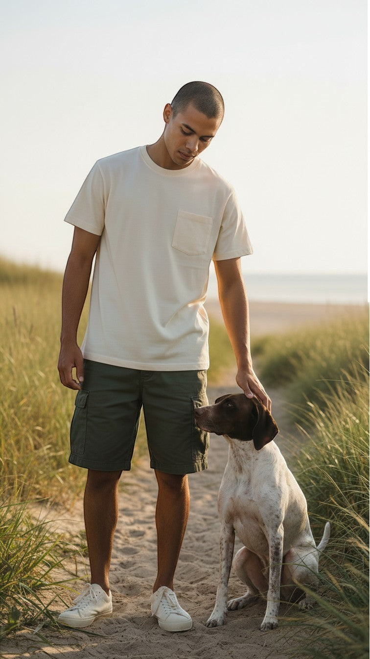 Scatter Creek Trading Co unisex cream heavyweight cotton pocket t-shirt worn by a man with a pointer dog on a beach